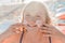 Close-up portrait of a young sweet and happy teenage girl smearing sunscreen on her face