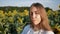 Close-up portrait of young woman agronomist on background of sunflower field