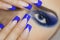 Close up portrait of young woman with big blue eyes and prefect manicure.