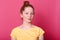 Close up portrait of young woman with bunch of hair, wearing yellow casual T shirt. Pretty female posing indoors isolated over