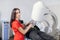 Close up portrait of young woman doctor in red uniform, working with modern ultrasonic lithotripter machine, making