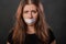 Close-up portrait of a young woman with duct tape sealed in her mouth, restriction of freedom of speech and censored