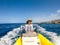 Close up and portrait of young woman having fun and enjoying her vacations and summer time driving a small boat or dinghy in the