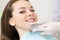 Close up portrait of Young women in dentist chair, Check and select the color of the teeth. Dentist makes the process of treatment