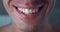 Close-up positive male millennial smile with teeth. Detail of relaxed male mouth smile at camera with white teeth, macro