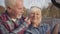 Close-up of positive mature Caucasian couple taking selfie in the autumn park. Happy modern European family enjoying