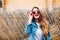 Close-up posrtait of magnificent female model in retro denim jacket, holding sunglasses and lookin up. Sensual young