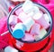 Close up of pot of multiple white marshmallows lying on table