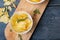 Close-up of potato chips in bowl with rosemary on serving board at wooden table