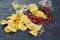 Close-up potato chips and ingredients on a black paper background.