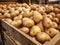 Close-up of potatoes in a wooden crate, ideal for agricultural marketing or food industry use.