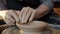 Close-up of potter`s hands making bowl from clay using throwing-wheel in workshop