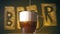 Close up of pouring Cold Light beer with foam in glass, slow motion. Oktoberfest