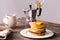 Close-up of pouring maple syrup on stack of pancakes.