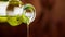 Close-up of pouring olive oil with the bottle on wood background