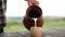 Close-up pouring white healthful vitamin milk in slow motion outdoors. Unrecognizable Caucasian man filling cup with