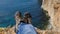 Close up POV of hiking boots of an independent male traveler on top of a mountain, looking at the view .