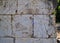 Close up of prayer-stuffed basalt brick wall in the ancient ruins of Capernaum