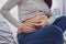 Close up of pregnant adorable woman measuring her stomach