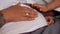Close-up pregnant belly of African American young woman with hands caressing tummy. Unrecognizable husband wife and