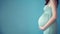 Close Up of a pregnant belly against pastel green background. Generative AI