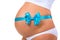 Close-up of pregnant belly with blue ribbon and bow. Concept of pregnancy. Newborn baby boy