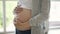 Close-up of pregnant belly and tender mother`s hands caressing and stroking baby bump with love and care. Happy