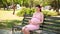 Close up of pregnant woman hands stroking belly on a Park bench in the summer