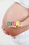 Close Up Of Pregnant Woman Holding Blocks Spelling BOY