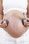 Close Up Of Pregnant Woman Holding Headphones Over Belly