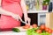 Close up pregnant woman with knife on kitchen cuts vegetables