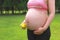 Close-up of pregnant woman mother belly, hold yellow toy smile emoji keep healthy positive attitude