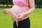 Close-up of pregnant woman mother belly, she is using a ruler to measure waistline keep healthy do exercise