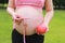 Close-up of pregnant woman mother belly, she is using a ruler to measure waistline an red apple beside keep healthy do exercise