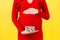 Close up of pregnant woman in red dress holding cubes with numbers of pregnancy weeks. Thirty weeks of pregnancy period at yellow