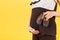 Close up of pregnant woman showing small boots for a baby boy at yellow background. Future mother is waiting for a child. Copy