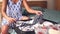 Close up of a pregnant woman sitting on the bed folding baby clothes and preparing hospital bag.