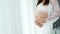 Close up of pregnant woman stroking belly on window background