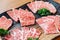 Close-up Premium Rare Slices many parts of Wagyu A5 beef with high-marbled texture on stone plate served for Yakiniku.