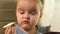 Close up of Preschool girl sitting at a table and eats bread and butter