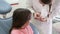 Close up of pretty girl and dentist having fun playing with rubber glove