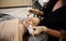 Close-up pretty woman receives facial microcurrent treatment from beautician at spa salon. Cosmetologist using electrical impulses