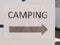 Close up of printed direction white and black sign camping