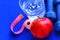 Close up of a pristine red apple two dumbbells and glass water