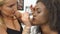 Close-up process of applying makeup for gorgeous african american model in a salon.