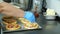 Close-up, the process of cooking several mini pizza from yeast dough, with sausage and cheese. Chef sprinkles pizza with