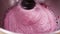 Close-up of the process of making cream, mousse, mixing the ingredients of pink color in a food processor. Slow motion.