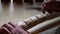 Close up process of man making wooden walking stick indoors during quarantine. Carving wood stick on the table using knife