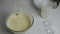 Close-up of the process of mixing eggs, kefir and flour with a whisk in a transparent bowl