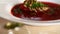 Close-up of the process of watering with garlic oil borscht with meat and finely sliced herbs.Borsch.